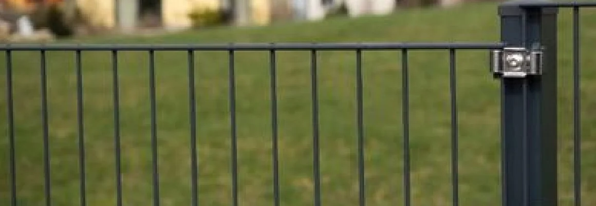 Metallzaun vor einem grünen Rasen